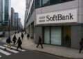Fachada de la sede de SoftBank en Tokio con peatones cruzando y edificios corporativos al fondo