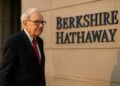 Warren Buffett caminando al atardecer frente al edificio de Berkshire Hathaway, tono reflexivo.