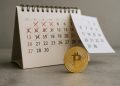 Moneda física de Bitcoin frente a un calendario con días tachados, sugiriendo rebote tras un mes difícil.