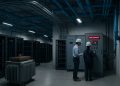 Ingenieros revisan panel eléctrico con alerta roja en centro de datos sin terminar