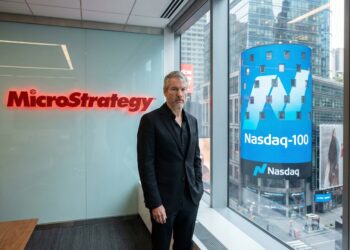 Michael Saylor con logos de MicroStrategy y Nasdaq-100.