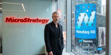 Michael Saylor con logos de MicroStrategy y Nasdaq-100.