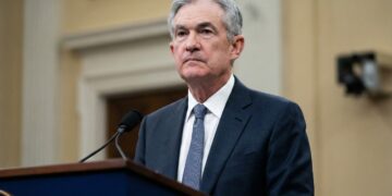 Jerome Powell, presidente de la Fed, serio en un atril oficial.