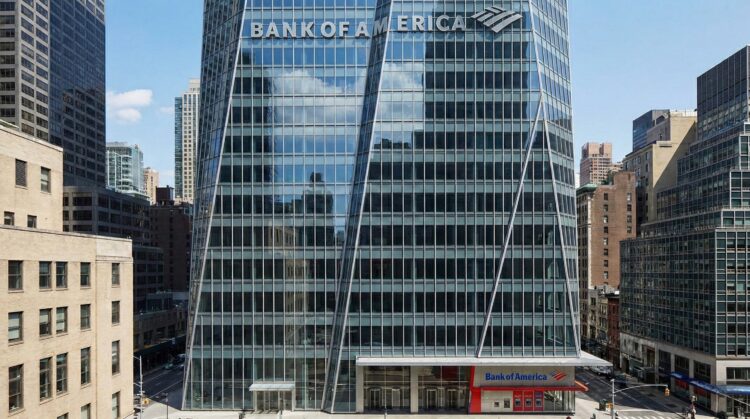 Fotografía de la Torre Bank of America en Nueva York, mostrando la fachada de cristal facetado con el gran letrero y logotipo de "BANK OF AMERICA" integrados en la parte superior. Una sucursal del banco es visible a nivel de calle.