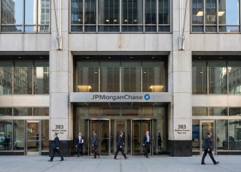 Entrada principal de la sede de JPMorgan Chase en 383 Madison Ave, NY; profesionales entran y salen.