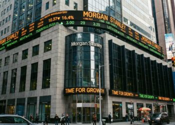 Vista exterior frontal del edificio de Morgan Stanley en 1585 Broadway, Nueva York. La imagen muestra la fachada integrada con grandes pantallas LED y tickers bursátiles iluminados en el entorno de Times Square, proyectando la actividad en tiempo real y la autoridad del banco de inversión en el mercado global.