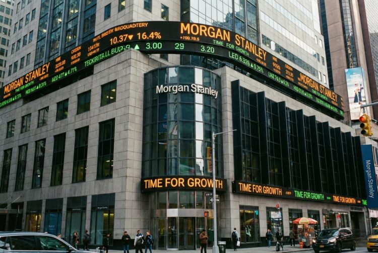 Vista exterior frontal del edificio de Morgan Stanley en 1585 Broadway, Nueva York. La imagen muestra la fachada integrada con grandes pantallas LED y tickers bursátiles iluminados en el entorno de Times Square, proyectando la actividad en tiempo real y la autoridad del banco de inversión en el mercado global.