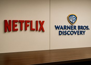 Logos en relieve de Netflix y Warner Bros. Discovery enfrentados en un muro corporativo.