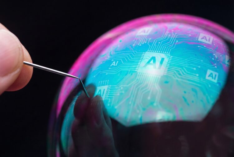 Fotografía macro conceptual que muestra una aguja plateada, sostenida por una mano, tocando la superficie de una gran burbuja de jabón iridiscente. La burbuja refleja patrones brillantes de circuitos digitales azules y el texto "AI" en el centro, sobre un fondo negro.