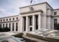 Exterior de la Fed en Washington bajo cielo gris, símbolo de presión para bajar tasas