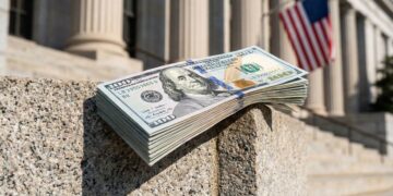 Fajo de billetes de 100 dólares frente al edificio de la Reserva Federal, EE. UU.