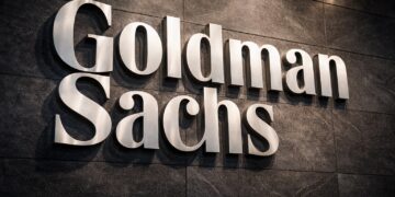 Logo físico de Goldman Sachs integrado en un muro institucional sólido.