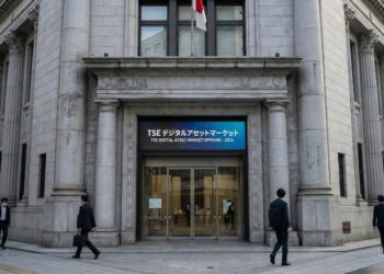 Fotografía exterior a nivel de calle de la entrada principal del edificio clásico de piedra de la Bolsa de Tokio (TSE). Sobre las puertas de vidrio, una gran pantalla digital azul muestra el texto bilingüe: "TSE デジタルアセットマーケット" y "TSE DIGITAL ASSET MARKET OPENING - 2026". Varios peatones con traje de negocios caminan por la acera frente a la institución financiera.