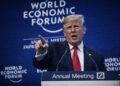 Donald Trump habla desde el podio del World Economic Forum, con gesto severo y el dedo índice levantado, frente a un fondo azul con el texto “World Economic Forum – Annual Meeting”, en una escena de fuerte carga política y confrontacional.
