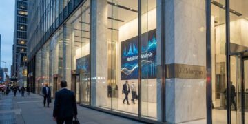 Fotografía exterior de la entrada acristalada de la sede de J.P. Morgan en una ciudad al atardecer. A través de los ventanales de piso a techo, se ve un vestíbulo iluminado donde destaca una gran pantalla digital que muestra gráficos financieros azules y el texto "Retail Flow Analysis". Una placa de metal en una columna de mármol adyacente dice "J.P. Morgan". Varias personas con vestimenta de negocios caminan por la acera y entran al edificio, reflejándose en el vidrio.