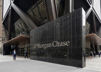 Cartel de JPMorgan Chase en piedra pulida frente a un edificio moderno con estructura en forma de X en Nueva York