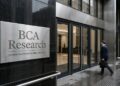 Fachada de BCA Research con placa metálica, puertas de cristal, interior moderno y una persona borrosa caminando.