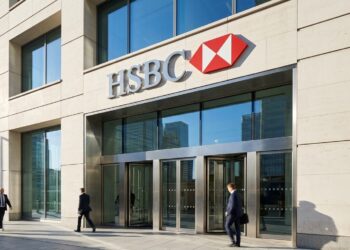 Fachada moderna de la sede de HSBC en Londres con el logo corporativo y empleados de traje caminando en un día soleado.