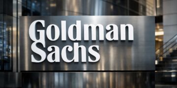 Logotipo de Goldman Sachs en edificio corporativo moderno.
