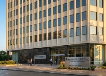Vista exterior de la Sede Global de Berkshire Hathaway en Kiewit Plaza, Omaha, con hombres de negocios caminando.