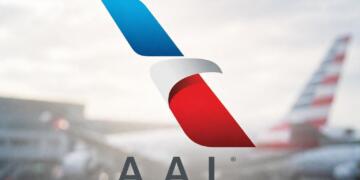 Logo de American Airlines centrado sobre fondo de aeropuerto desenfocado.