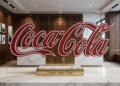 Logo de Coca-Cola sobre escritorio en entorno corporativo neutro