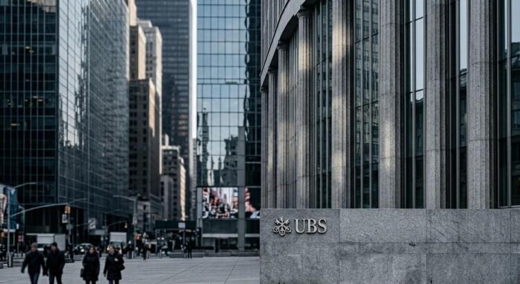Fachada del edificio UBS en Nueva York con su logo y gente caminando en la calle.