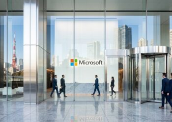 Fachada de vidrio de la oficina de Microsoft en Tokio con el logotipo y el horizonte de la ciudad al fondo.