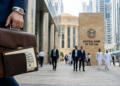 Un hombre de traje lleva un maletín frente al Banco Central de los EAU en Dubái.