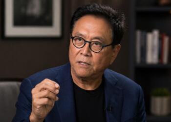 Robert Kiyosaki en entorno institucional con expresión analítica.
