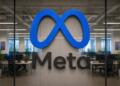 Logo de Meta en gran formato con oficina corporativa desenfadada al fondo.
