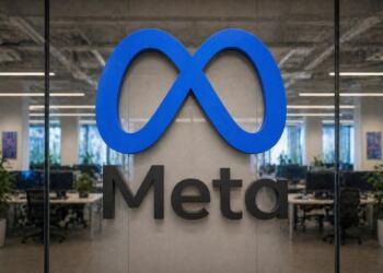 Logo de Meta en gran formato con oficina corporativa desenfadada al fondo.