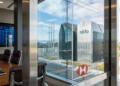 Sala de juntas con logo de HSBC y vista exterior a edificio con logo de Oklo.
