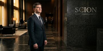 Michael Burry con traje en el vestíbulo de Scion Asset Management con luz matutina.