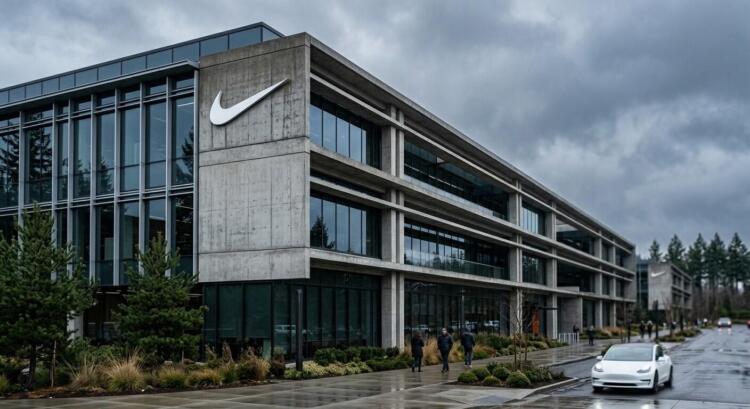 Fachada de concreto y vidrio de un edificio de Nike con un gran logo de la marca.