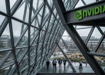 El logo de Nvidia sobre arquitectura de vidrio y acero con empleados.