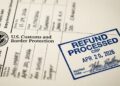 Formulario de CBP con sello azul de "REFUND PROCESSED" y logo de la agencia en primer plano.
