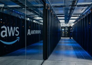 Pasillo de centro de datos moderno con logotipos de AWS y Anthropic en paneles de vidrio.