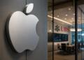 Logo de Apple en primer plano con oficina de UBS al fondo.