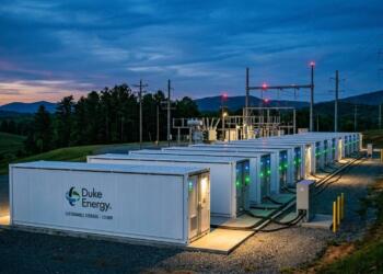 Unidades de batería de Duke Energy de 100MW en una subestación eléctrica con montañas al fondo.