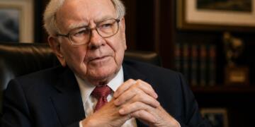 Warren Buffett en oficina con gesto serio y mirada reflexiva.