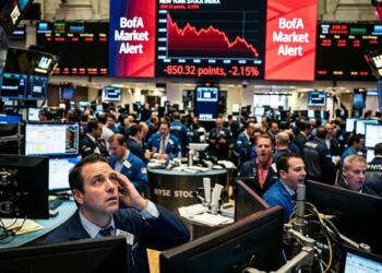 Trader estresado en la bolsa bajo pantalla roja con alerta de BofA en Wall Street.
