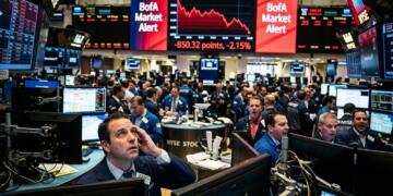 Trader estresado en la bolsa bajo pantalla roja con alerta de BofA en Wall Street.