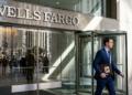Hombre de traje azul lleva portafolios de Alcoa frente a edificio de Wells Fargo