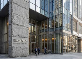 Entrada de la Sede Global de BlackRock con logo en pilar de piedra y rascacielos de fondo.
