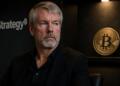 Michael Saylor en entorno corporativo con referencia sutil a Bitcoin.