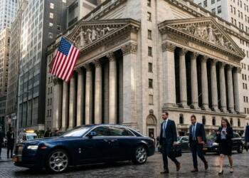 Hombres de negocios caminando por la calle de Nueva York con un Rolls Royce azul de fondo.