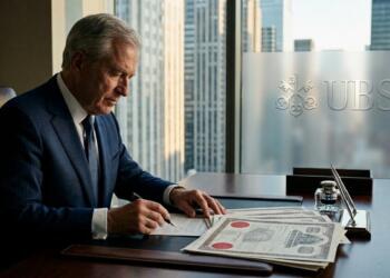 Oficina de UBS con el logo en el vidrio, un ejecutivo firma contratos con sellos y vista a la ciudad.