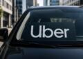 Logo de Uber en parabrisas con entorno urbano sobrio de fondo