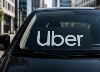 Logo de Uber en parabrisas con entorno urbano sobrio de fondo